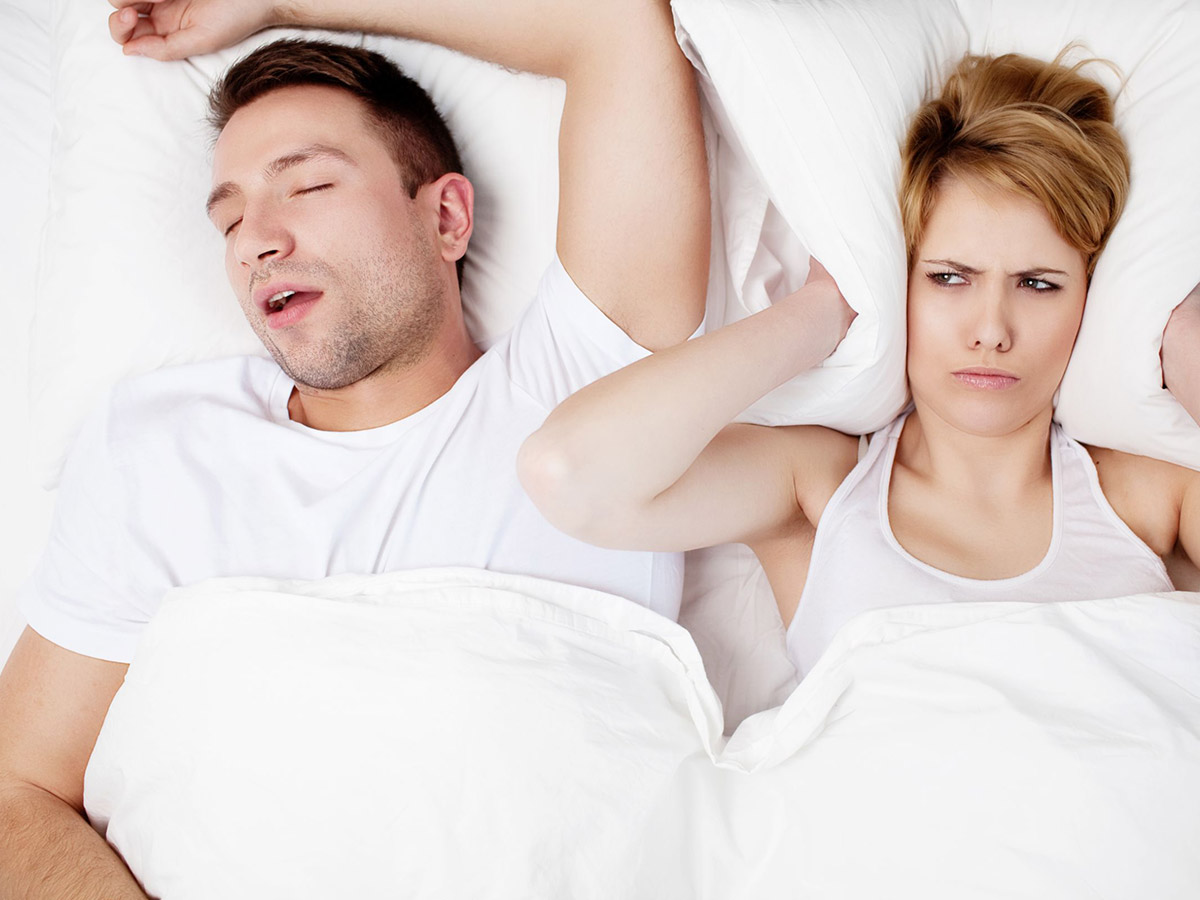 Sleep Apnea wife with pillow and husband snoring alternate photo
