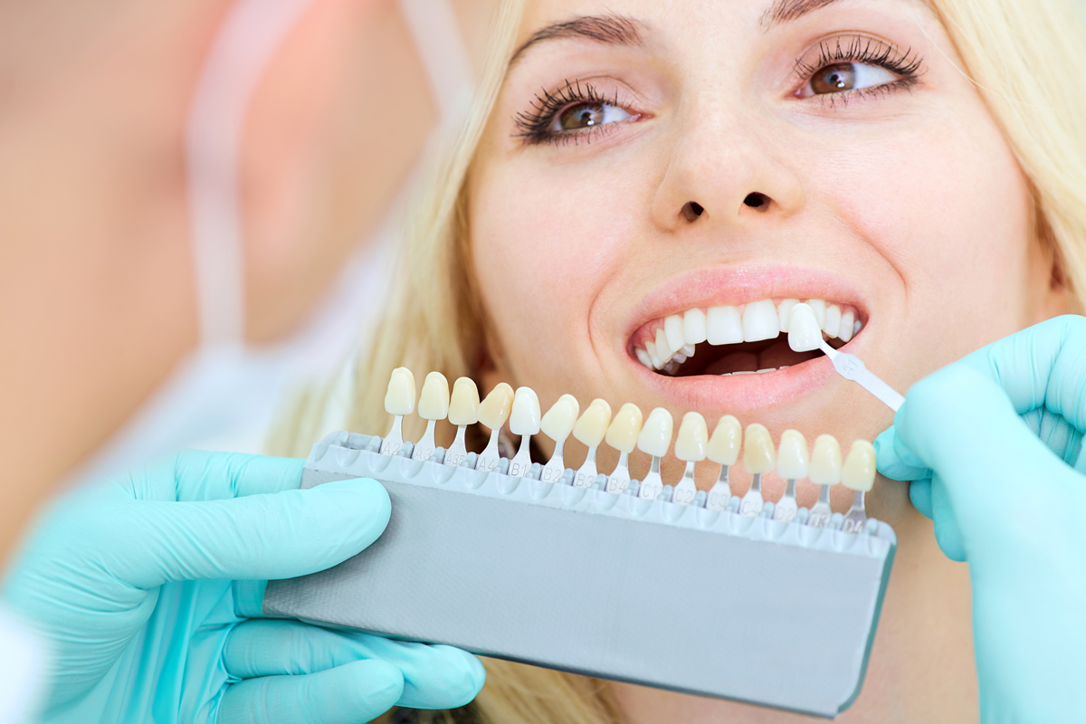 Cosmetic Dentistry applying veneers to woman's teeth