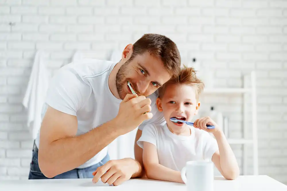 Preventative Dentistry of Father and son brushing teeth